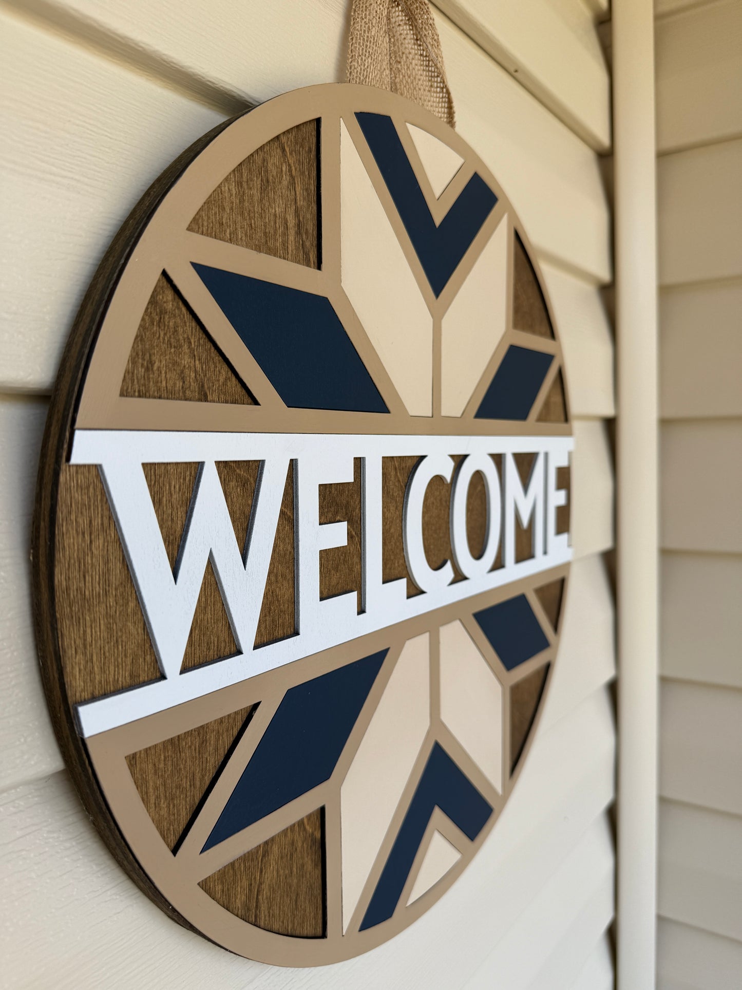 Decorative 'WELCOME' sign with geometric patterns on a neutral background