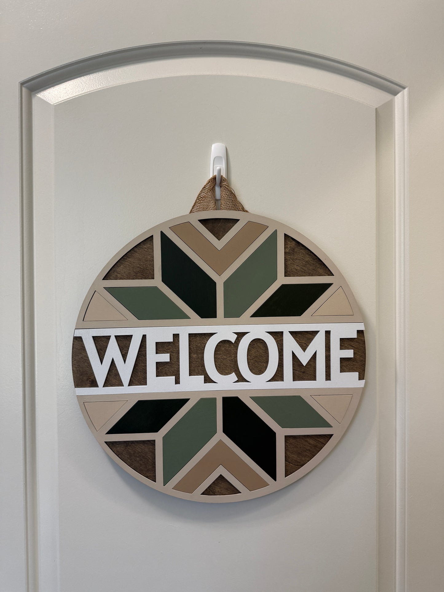 Decorative wall art with geometric patterns and the word 'Welcome' on a white background