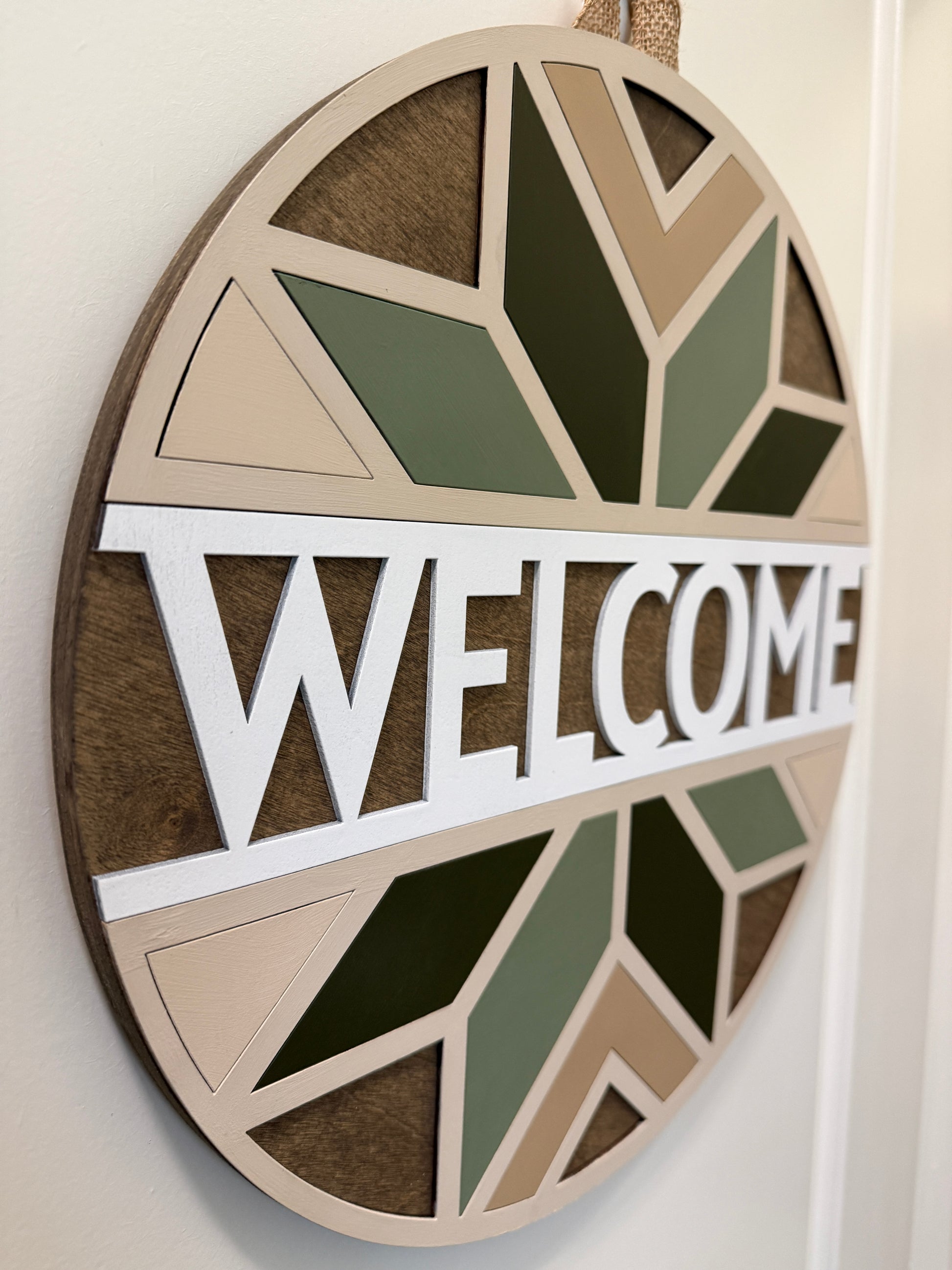 Decorative 'WELCOME' sign with geometric patterns on a white background